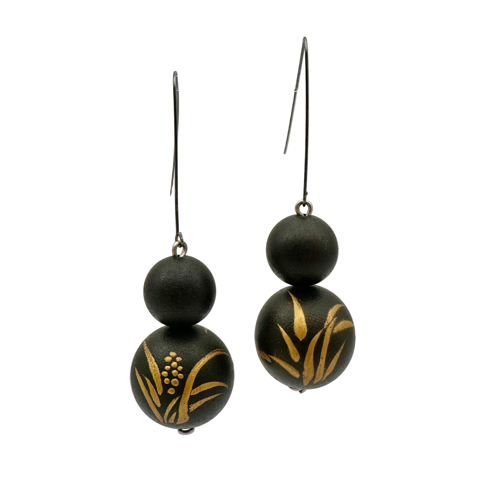 Black earrings with gold leaf patterns on a clear background
