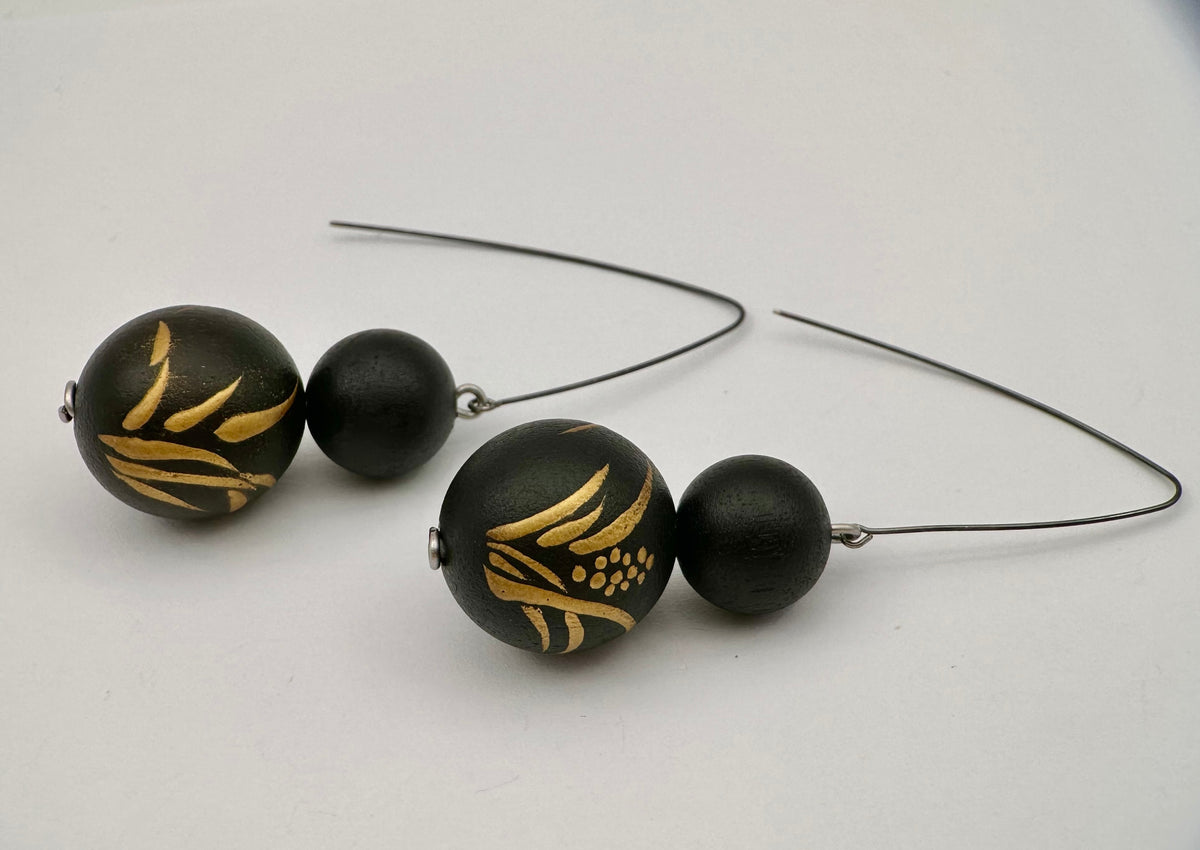 Acorus Grass Lacquer Quasi-Maki-e Earrings — Black beaded earrings with gold patterns on a white background