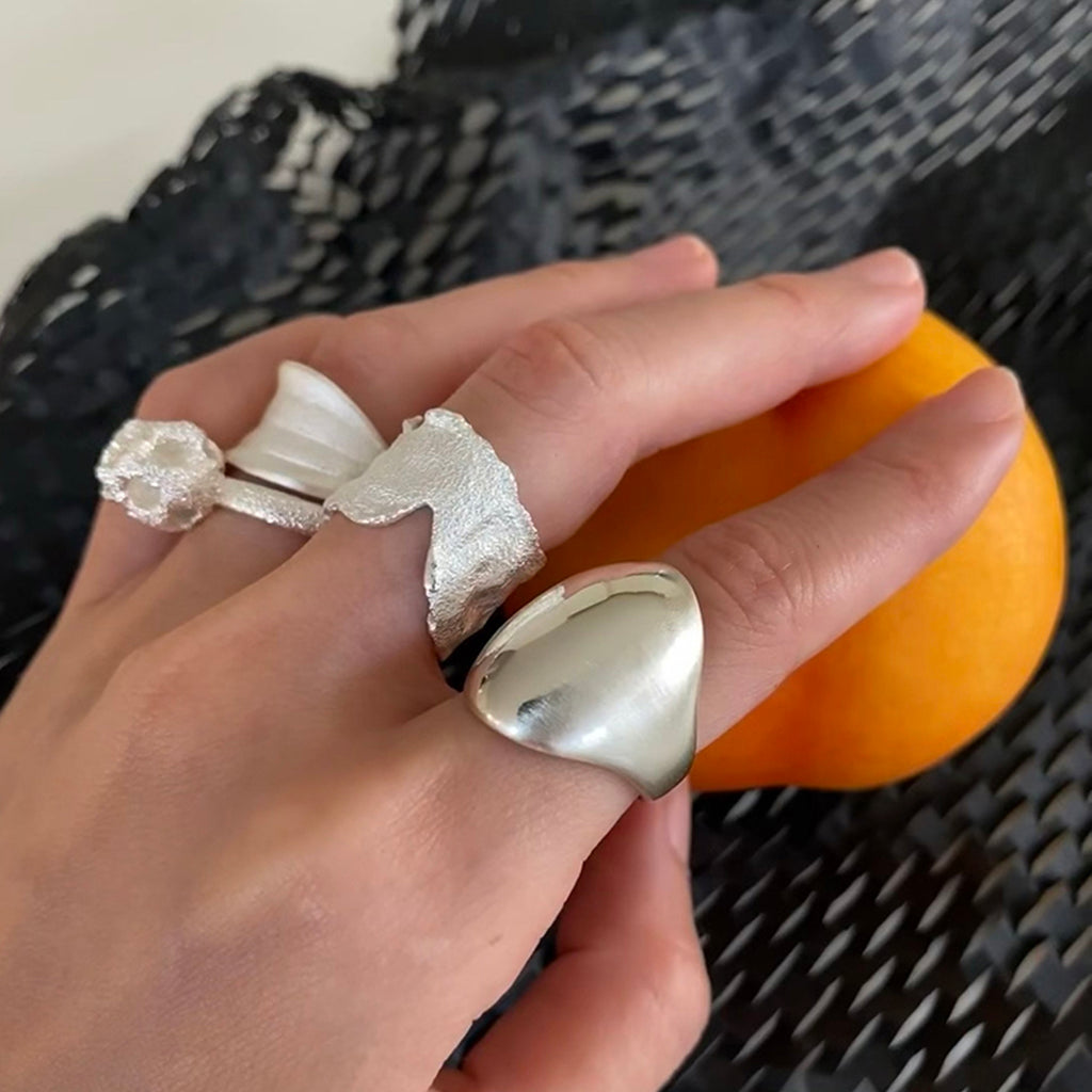 Amazon · Dome Ring — Hand wearing two silver rings with a blurred background