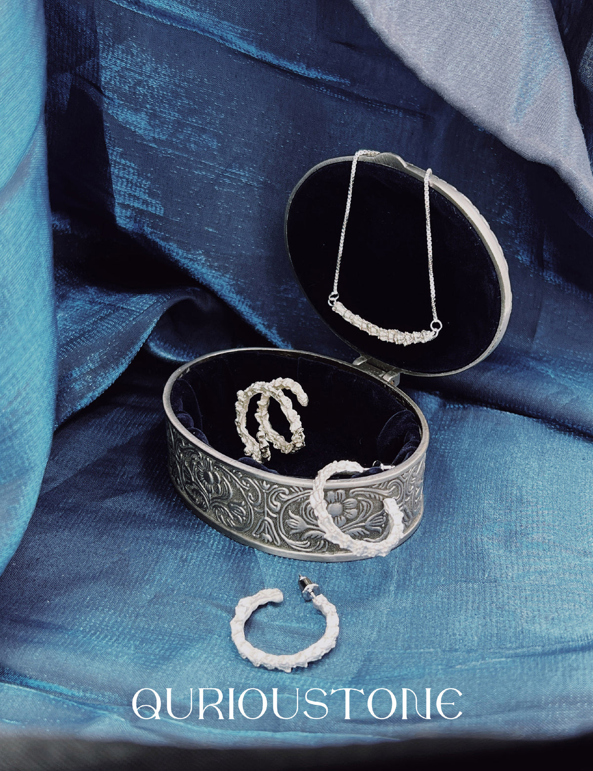 Amazon · Double Coil Snakebone Silver Ring — Jewelry box with necklaces on a blue fabric background, featuring the brand