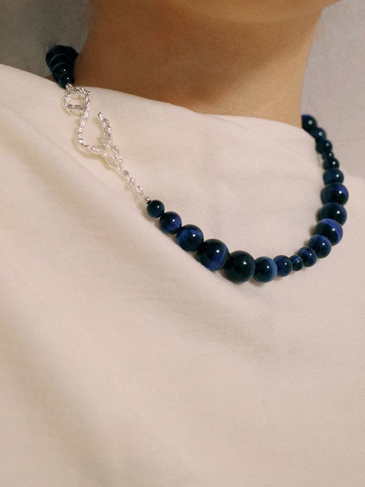 Amazon · Snakebone S-Hook Tiger’s Eye Choker Necklace — Necklace with blue beads and silver chain on a plain background