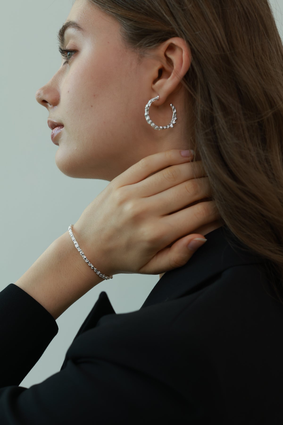 Amazon · Snakebone Silver Bangle Bracelet — Person adjusting an earring on another person with a neutral background