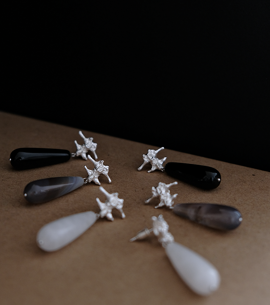 Amazon · Spine & Quartz Raindrop Earrings — Jewelry set with star-shaped pendants on a dark background
