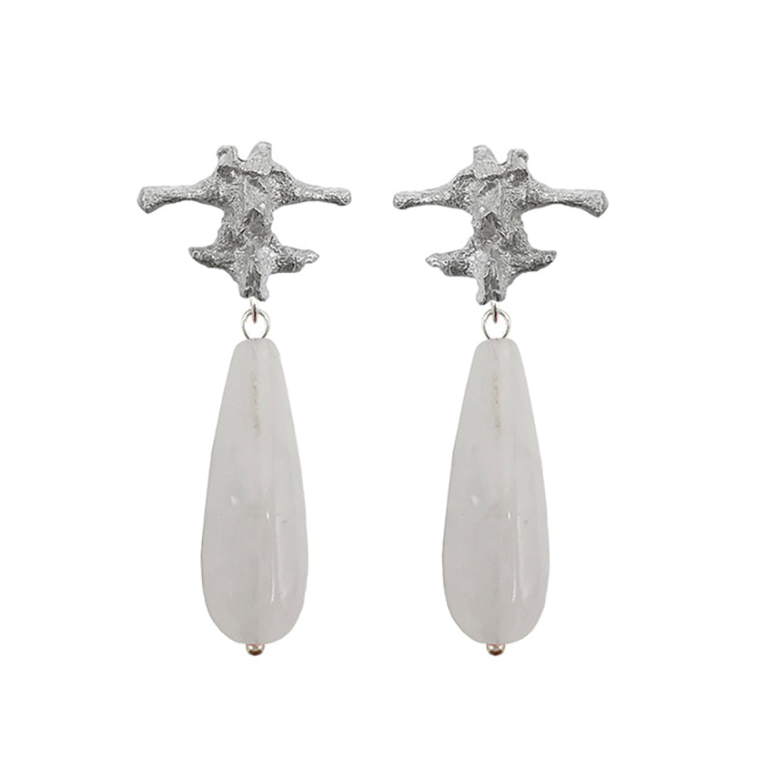 Amazon · Spine & Quartz Raindrop Earrings — Pair of silver star-shaped earrings with teardrop-shaped white stones on a white