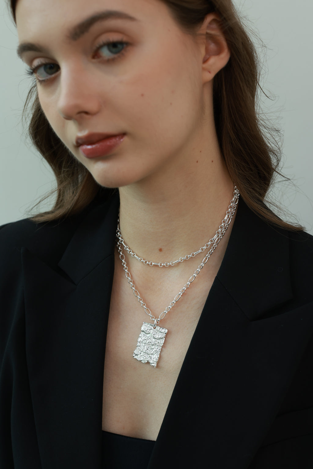 Amazon · Tree Grain Long Necklace — Woman wearing a delicate silver necklace with a rectangular pendant.