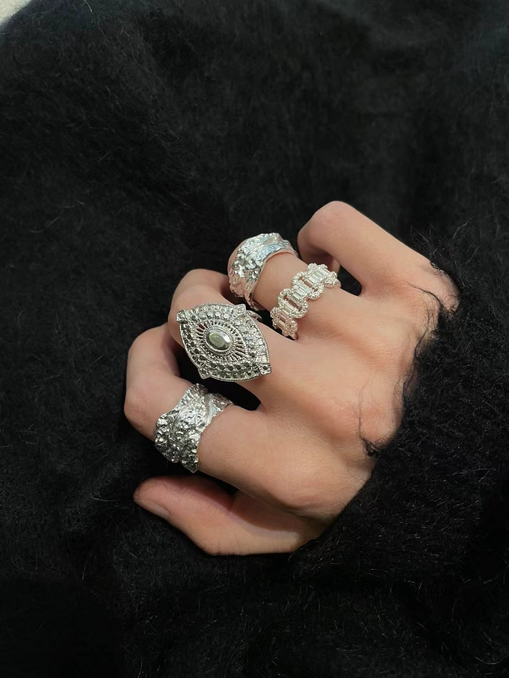 Amazon · Tree Grain Wide Band Silver Ring — Hand wearing multiple silver rings on a black background