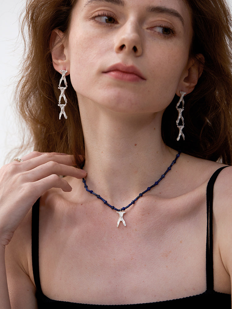 Amazon · Wishbone Lapis Necklace — Woman wearing a blue beaded necklace with starfish pendants and matching earrings.