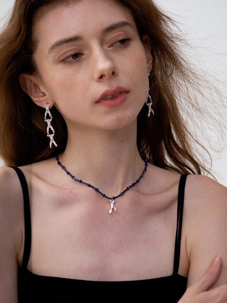 Amazon · Wishbone Lapis Necklace — Woman wearing a necklace and earrings with a neutral background