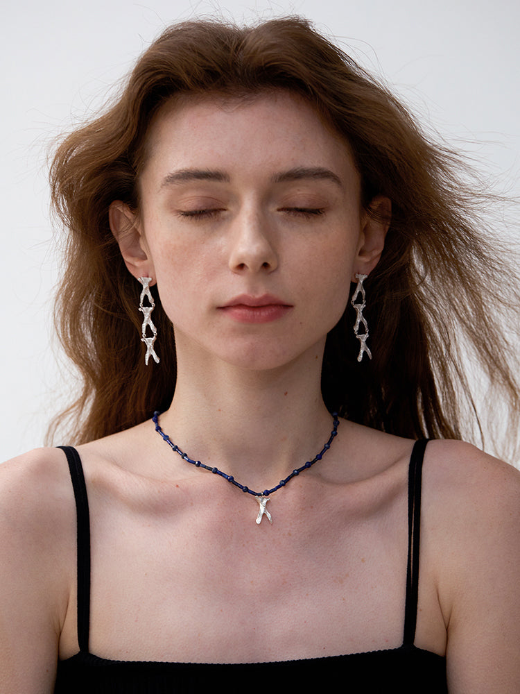 Amazon · Wishbone Long Earrings — Woman wearing a necklace and earrings against a white background