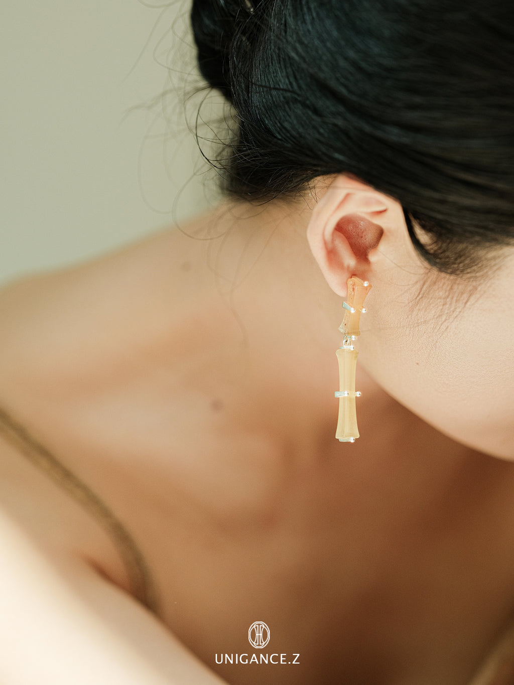 Bamboo Branch Drop Earrings — Close-up of a person wearing gold earrings with a blurred background