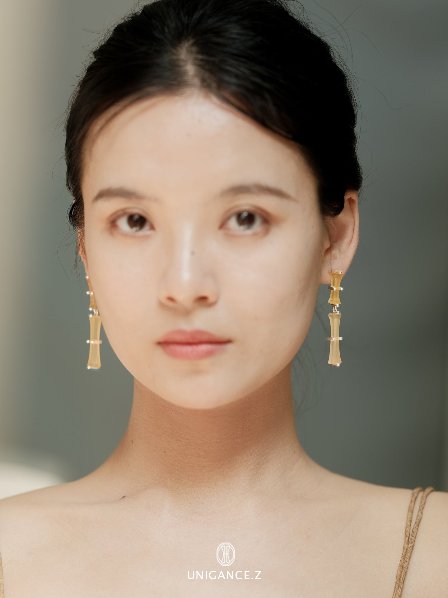 Bamboo Branch Drop Earrings — Woman wearing gold earrings with a neutral background
