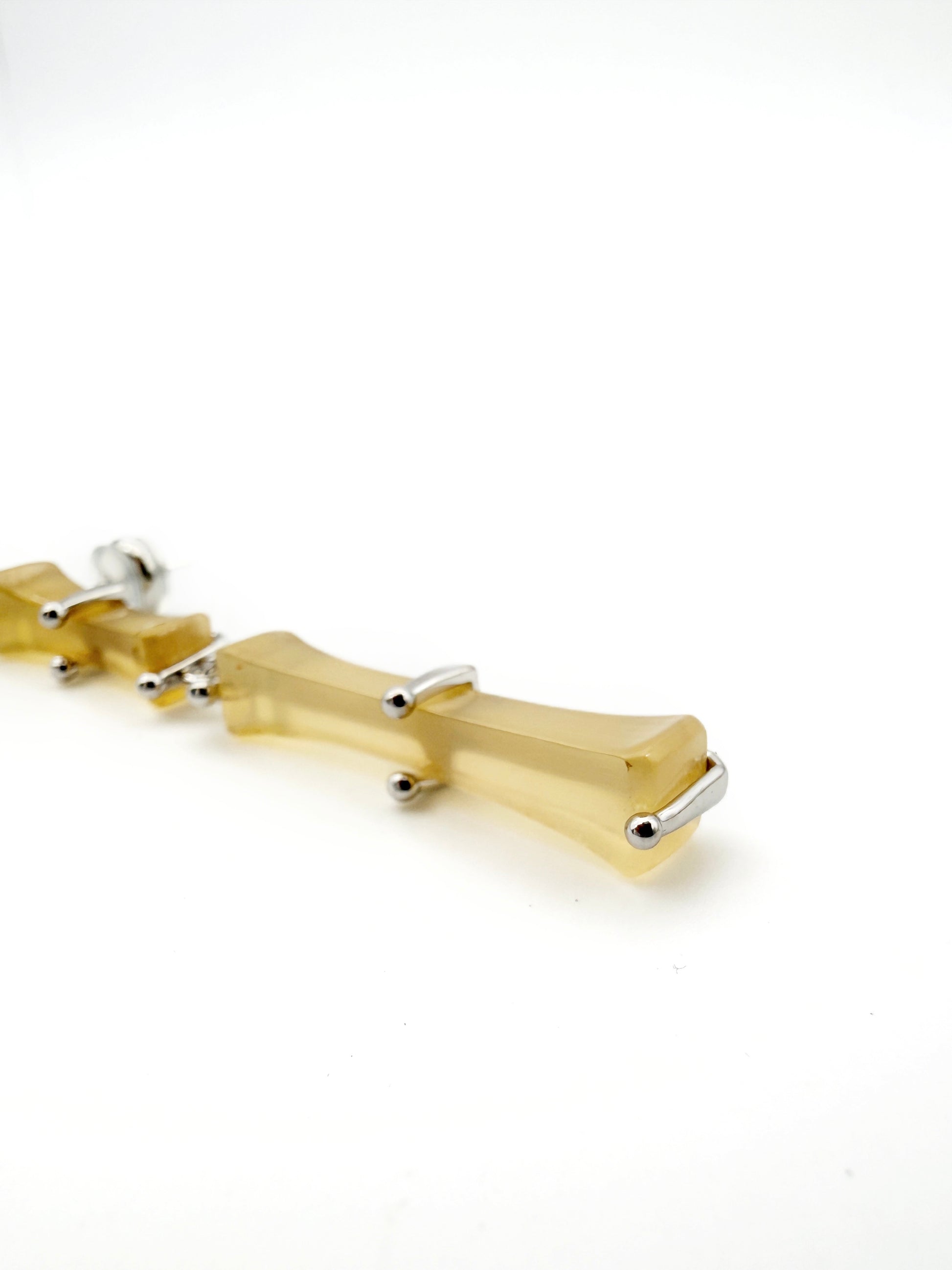Bamboo Branch Drop Earrings — Gold bracelet with silver accents on a white background