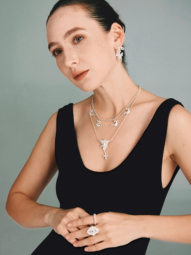 Baroque Totem Choker — Woman wearing a black dress with silver jewelry on a gray background