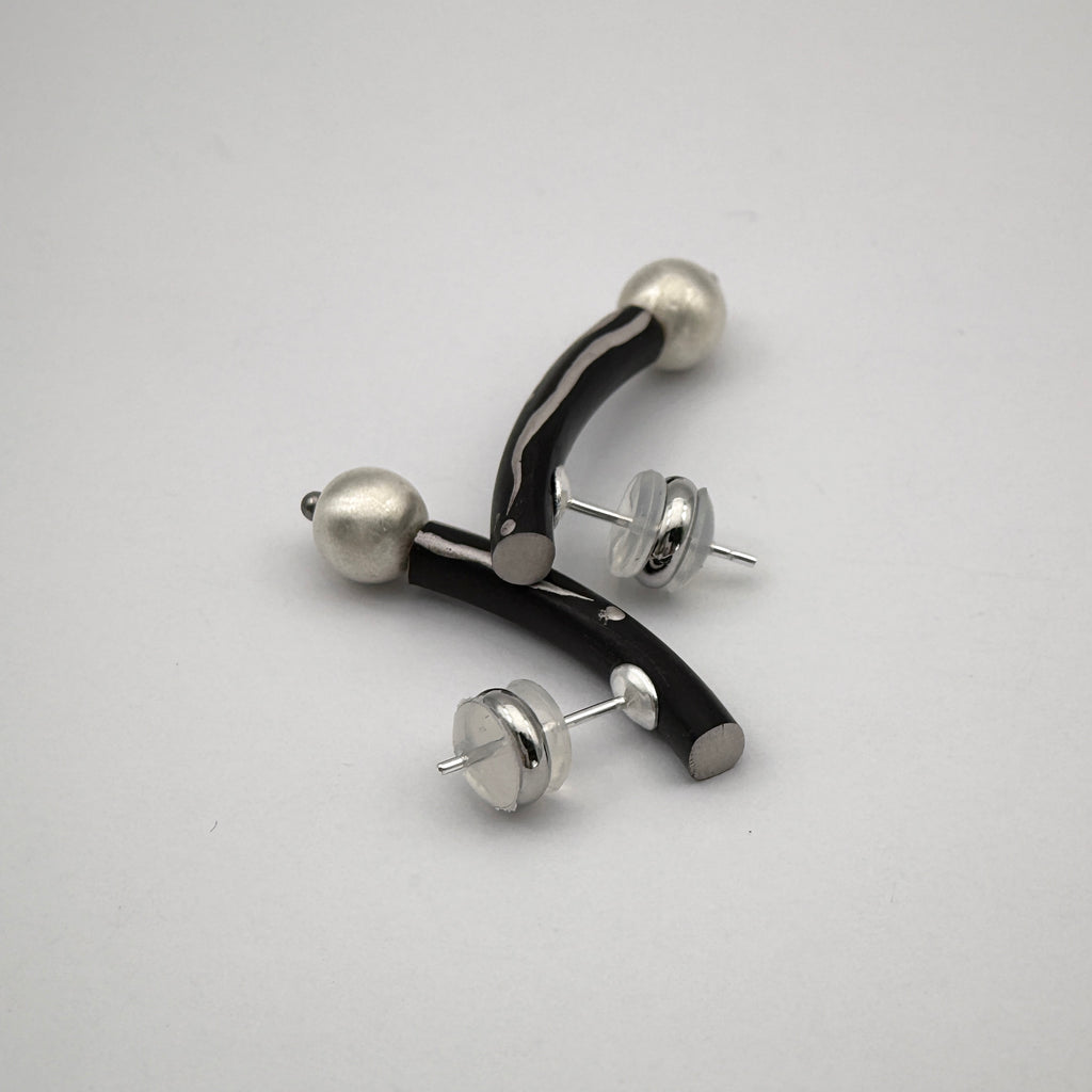 Black Orchid Lacquer Quasi-Maki-e Earrings — Pair of earrings with black and silver design on a white background