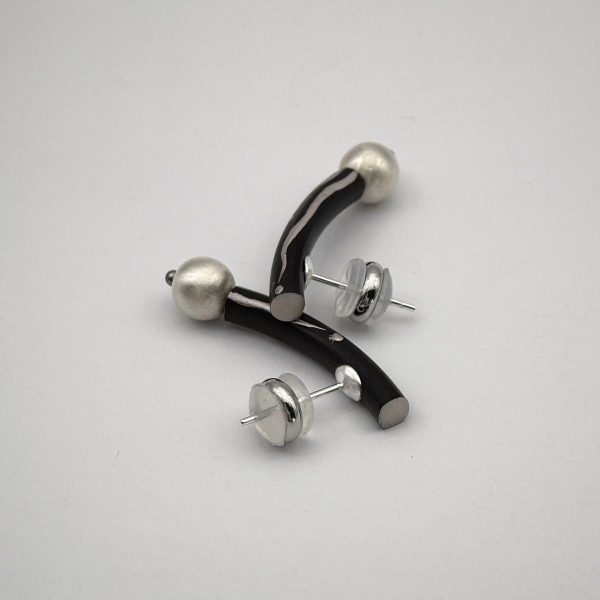 Black Orchid Lacquer Quasi-Maki-e Earrings — Pair of earrings with black and silver design on a white background