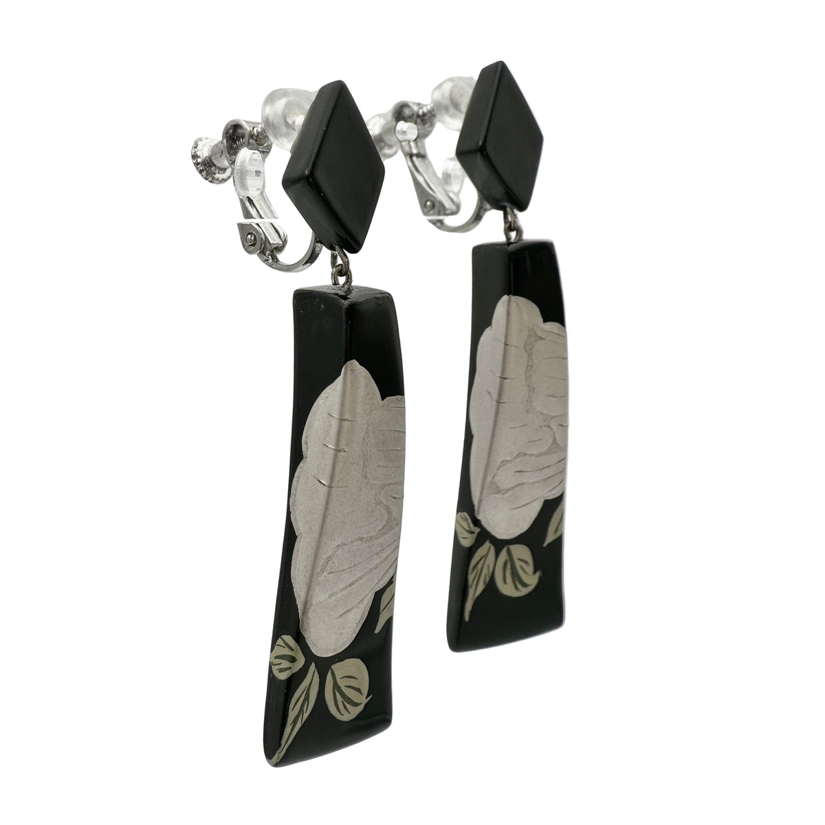 Black Peony Lacquer Quasi-Maki-e Earrings — Black earrings with leaf patterns on a clear stand