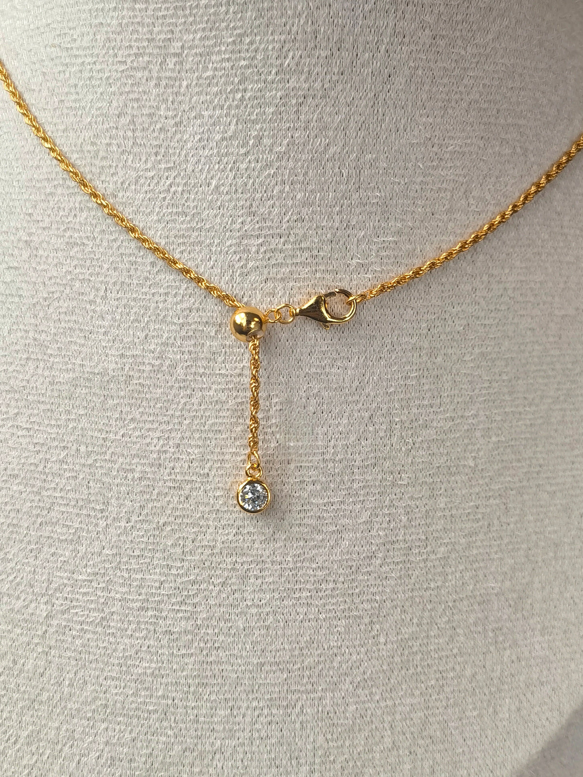 Blood Amber Flower Necklace — Gold necklace with a pendant on a gray mannequin bust