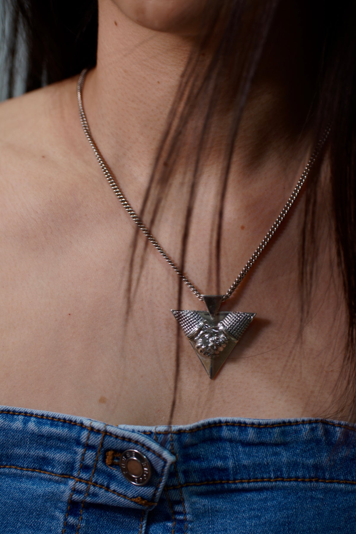 Brazilian Jiu-Jitsu Monkey Grip Necklace — Close-up of a person wearing a necklace with a detailed pendant, focusing on the