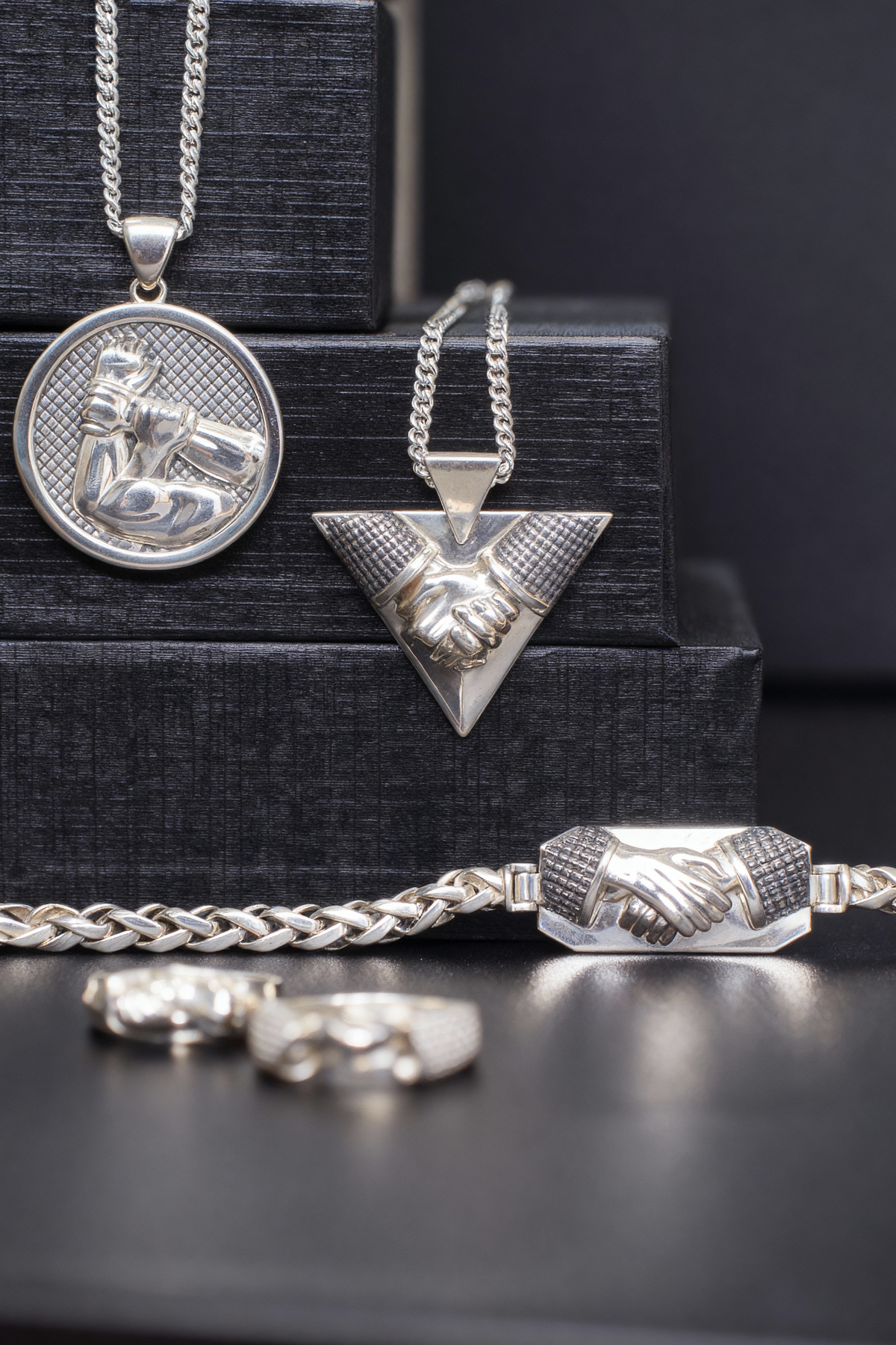 Brazilian Jiu Jitsu Necklace — Collection of silver necklaces and pendants on a black background