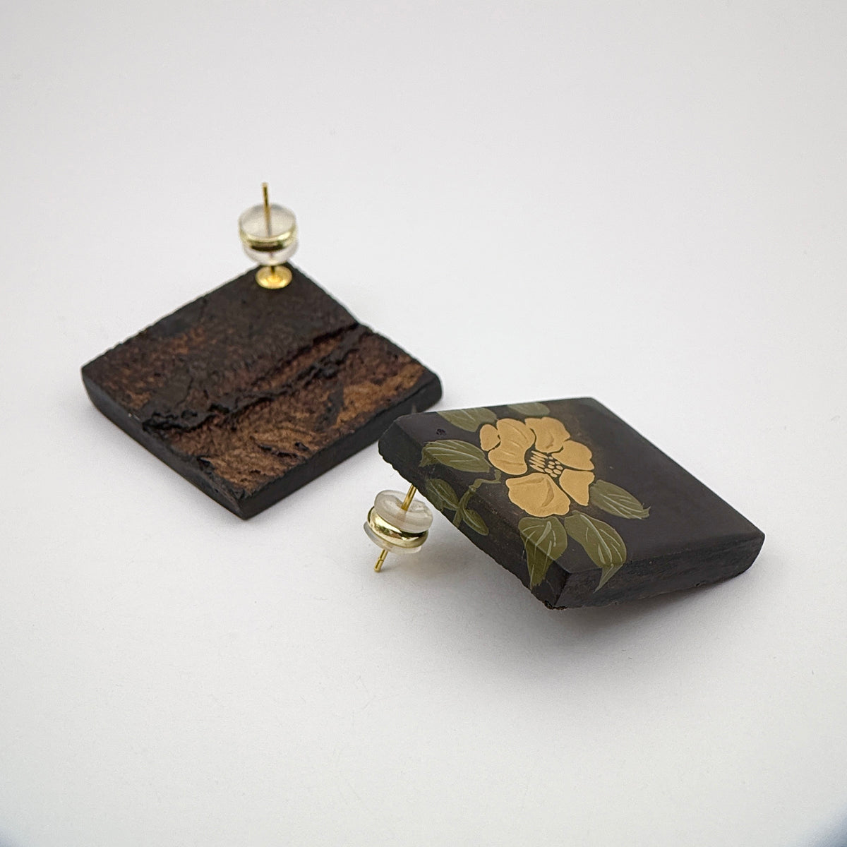 Camellia Lacquer Quasi-Maki-e Earrings — Pair of earrings with floral design on a white background