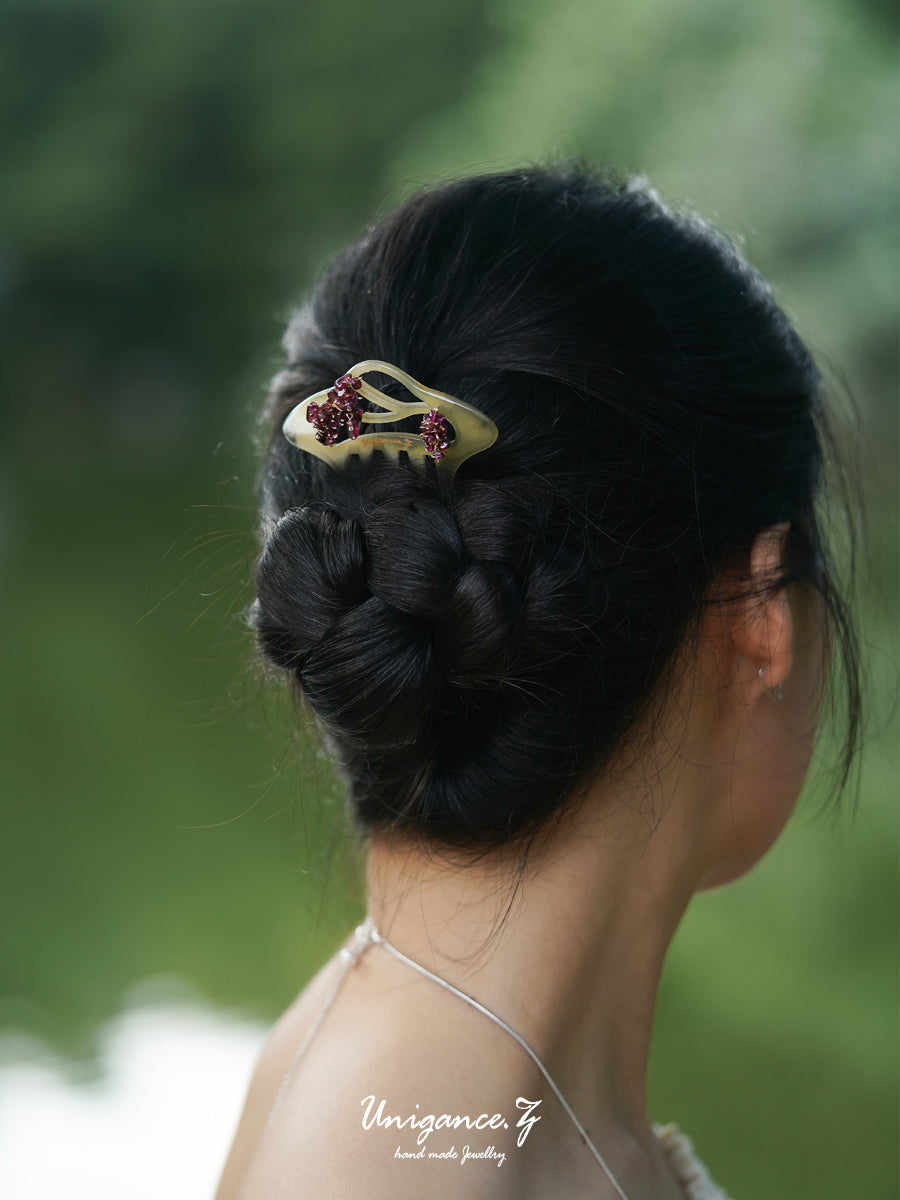 Crimson Bloom Branch Hair Comb — Person with braided hair wearing a decorative hairpin against a blurred green background