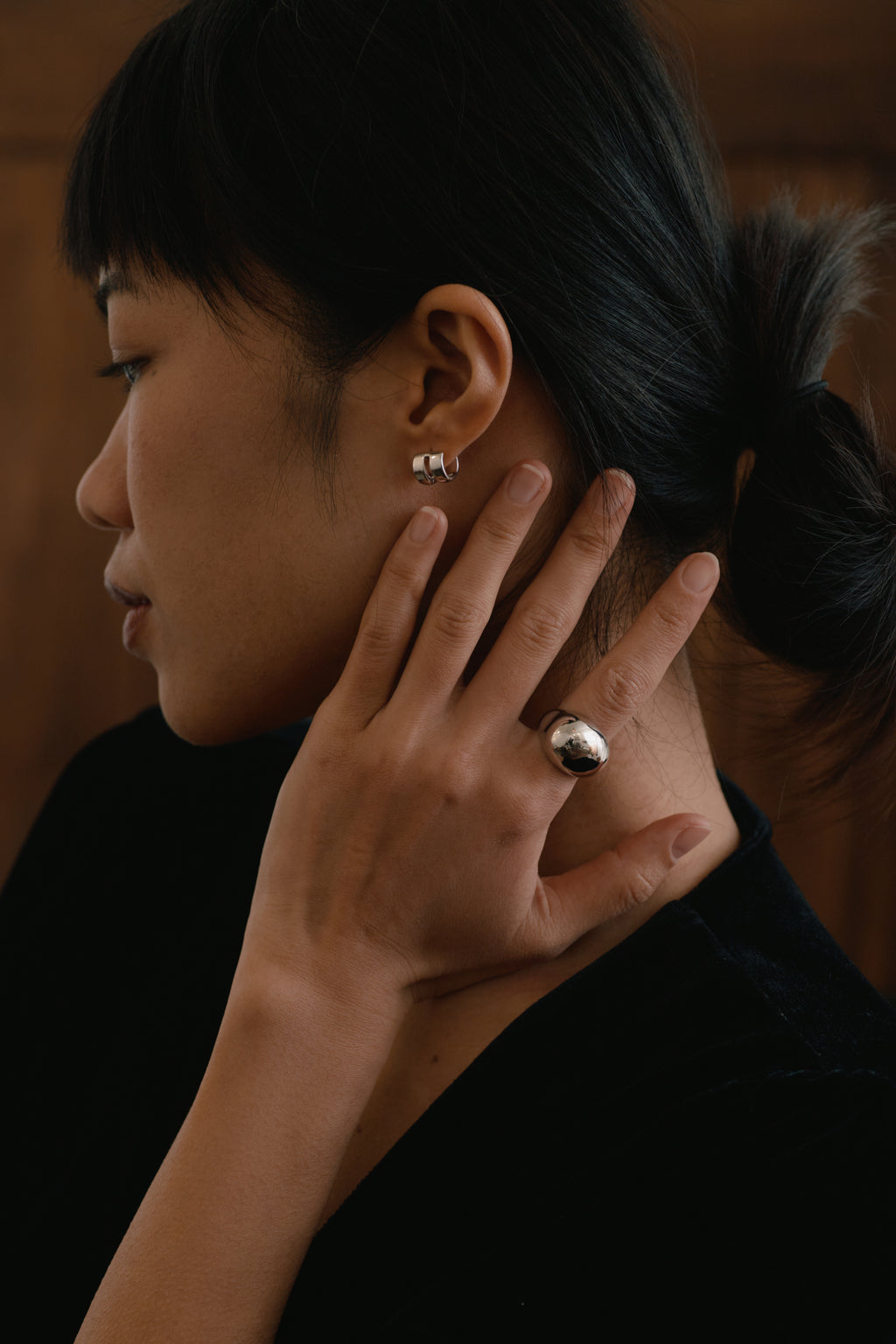 Double-Band Illusion Earrings — Close-up of a person wearing earrings and a ring, with a blurred background