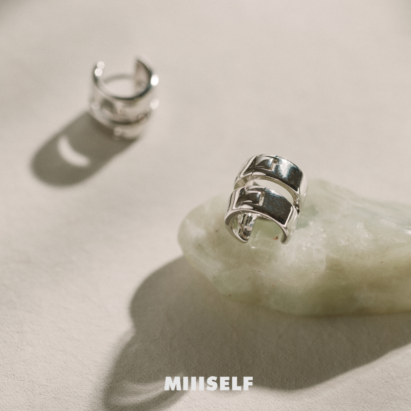 Double-Band Illusion Earrings — Silver hoop earrings on a textured beige surface with 'MIUSELF' branding.