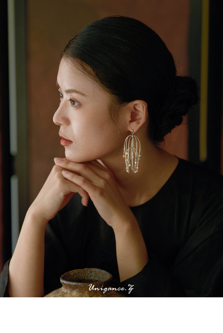 Drooping Begonia Drop Earrings — Woman wearing large hoop earrings with a blurred background