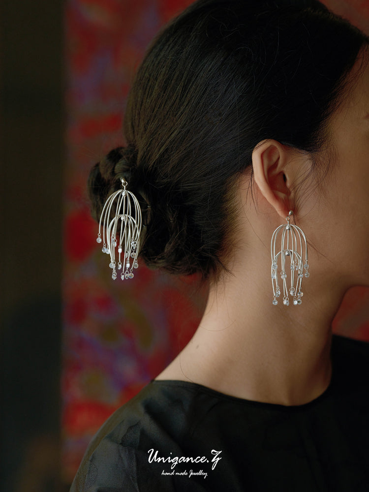 Drooping Begonia Hairpin — Person wearing silver earrings with a blurred background