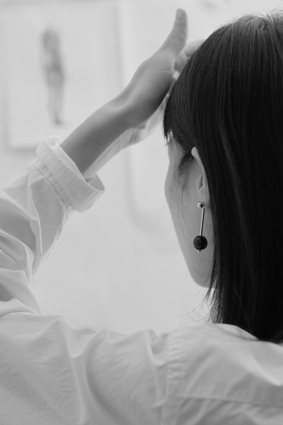 Geometric Sphere Drop Earrings — Person wearing a white shirt with a blurred background