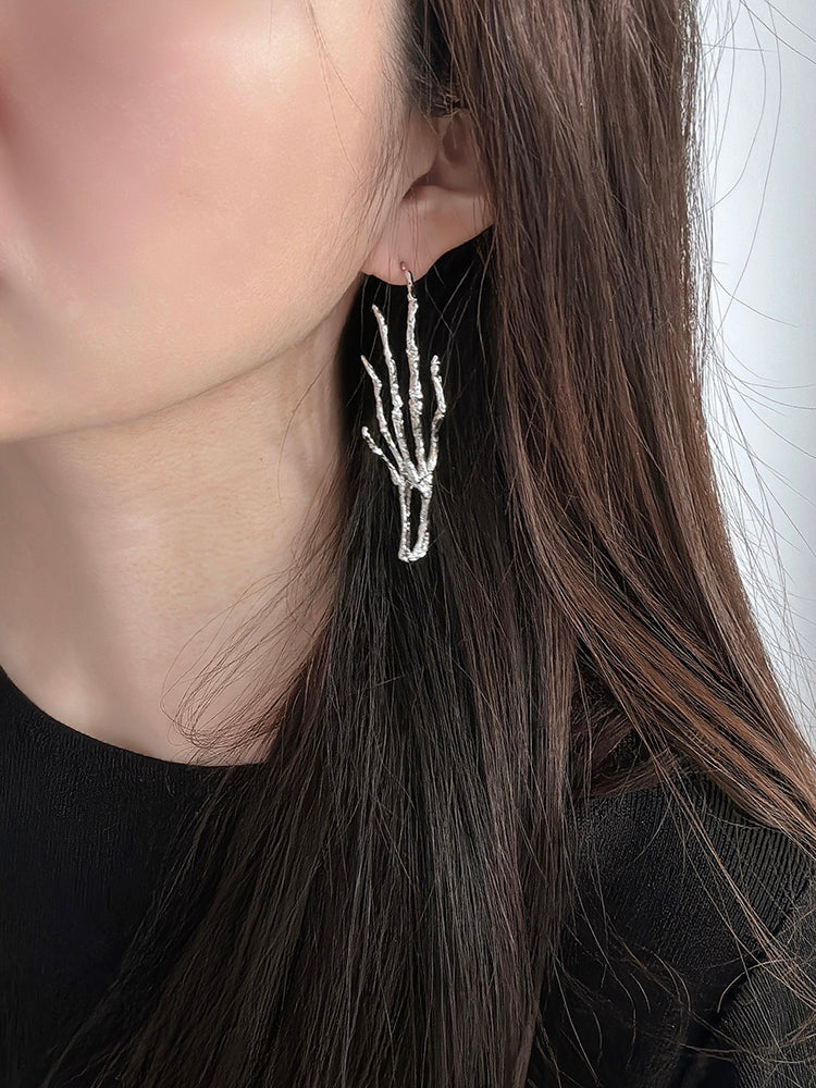 Gold Digger · Long Claw Earring (Single) — Close-up of a person wearing a unique silver hand-shaped earring.