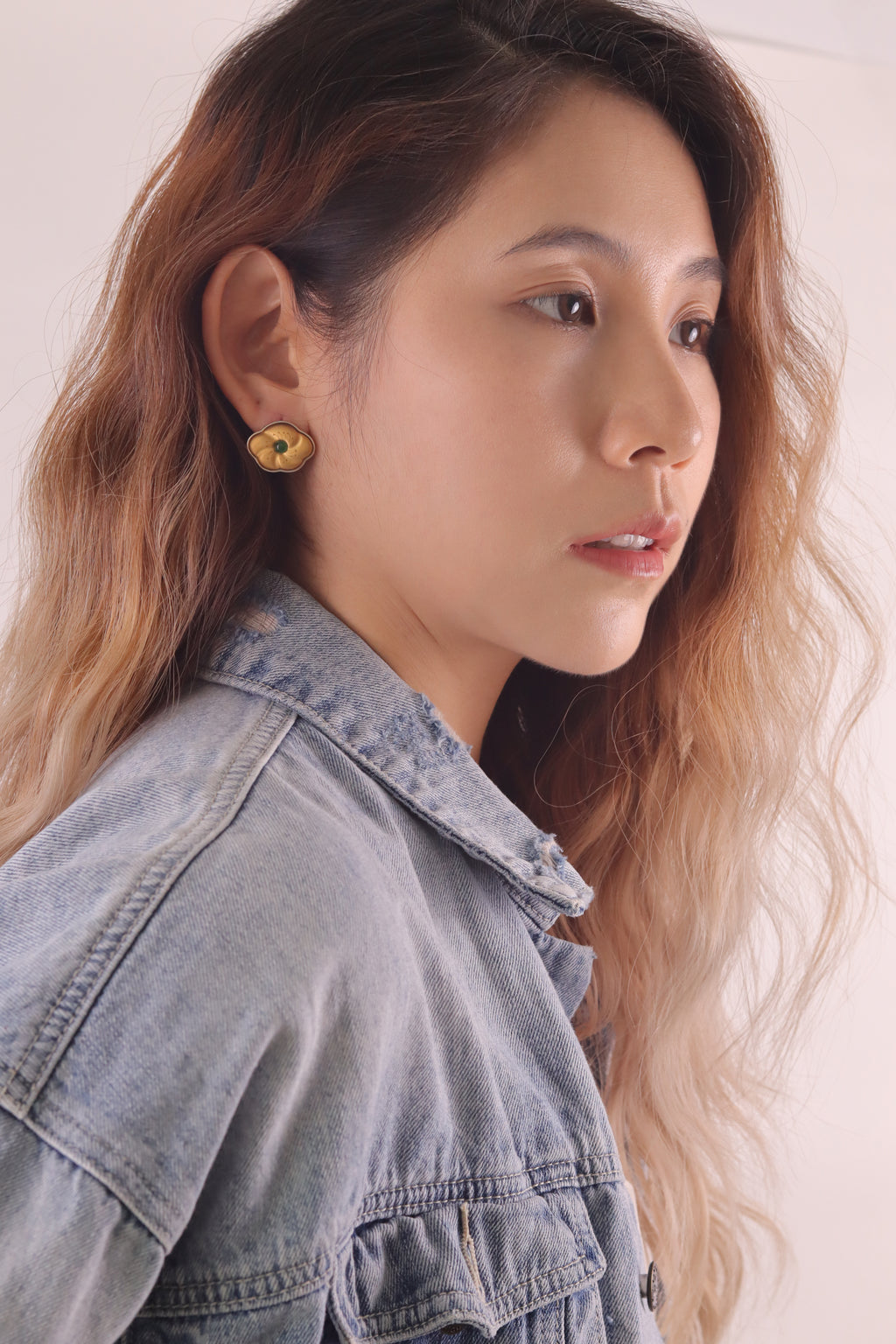 Golden Peach Blossom Lacquer Quasi-Maki-e Earrings — Woman wearing a denim jacket with a plain background
