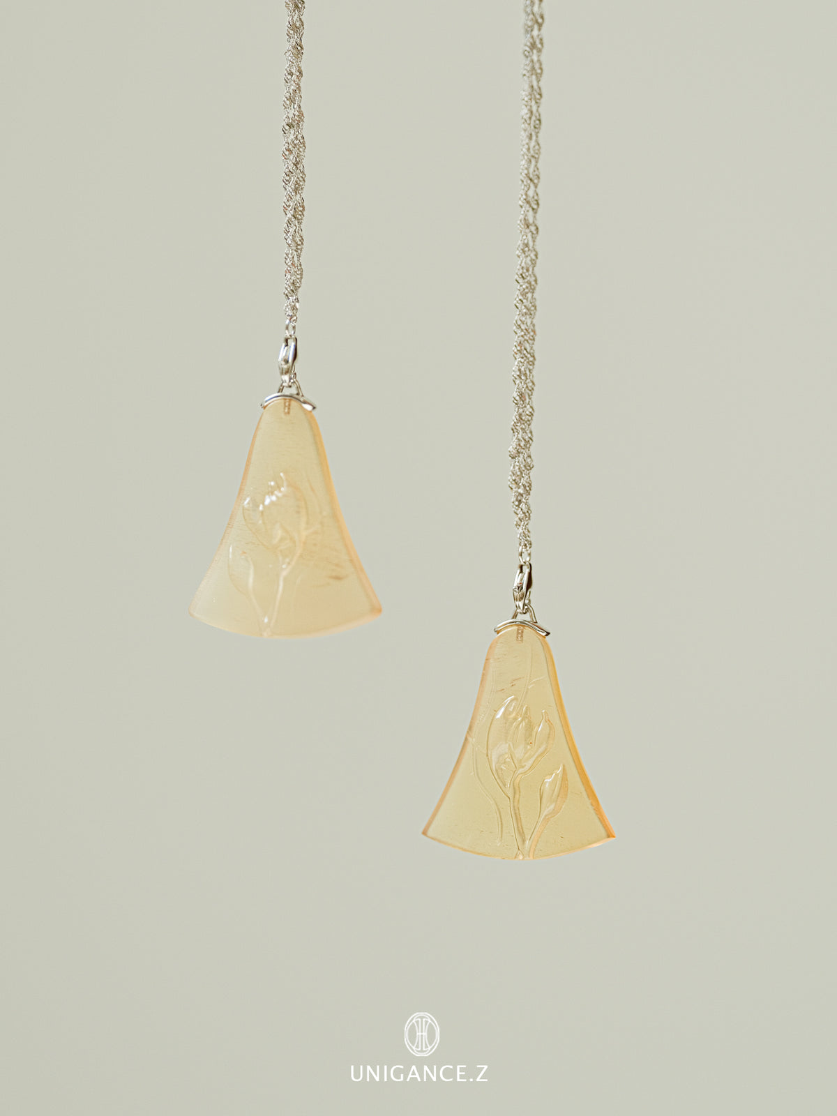 Gourd Vine Long Necklace — Two pendant necklaces with beige stone pendants on a light gray background.