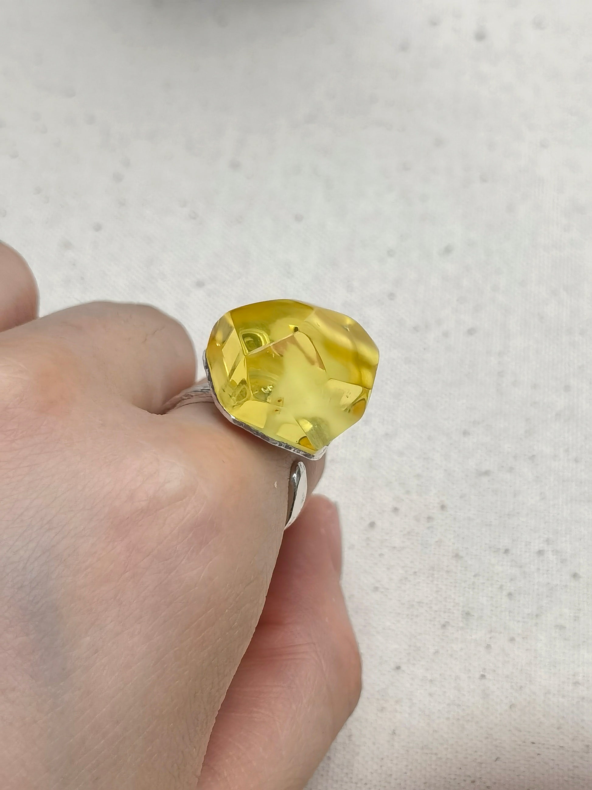 Hammered sterling silver ring with golden beeswax amber, designed with an adjustable open band.