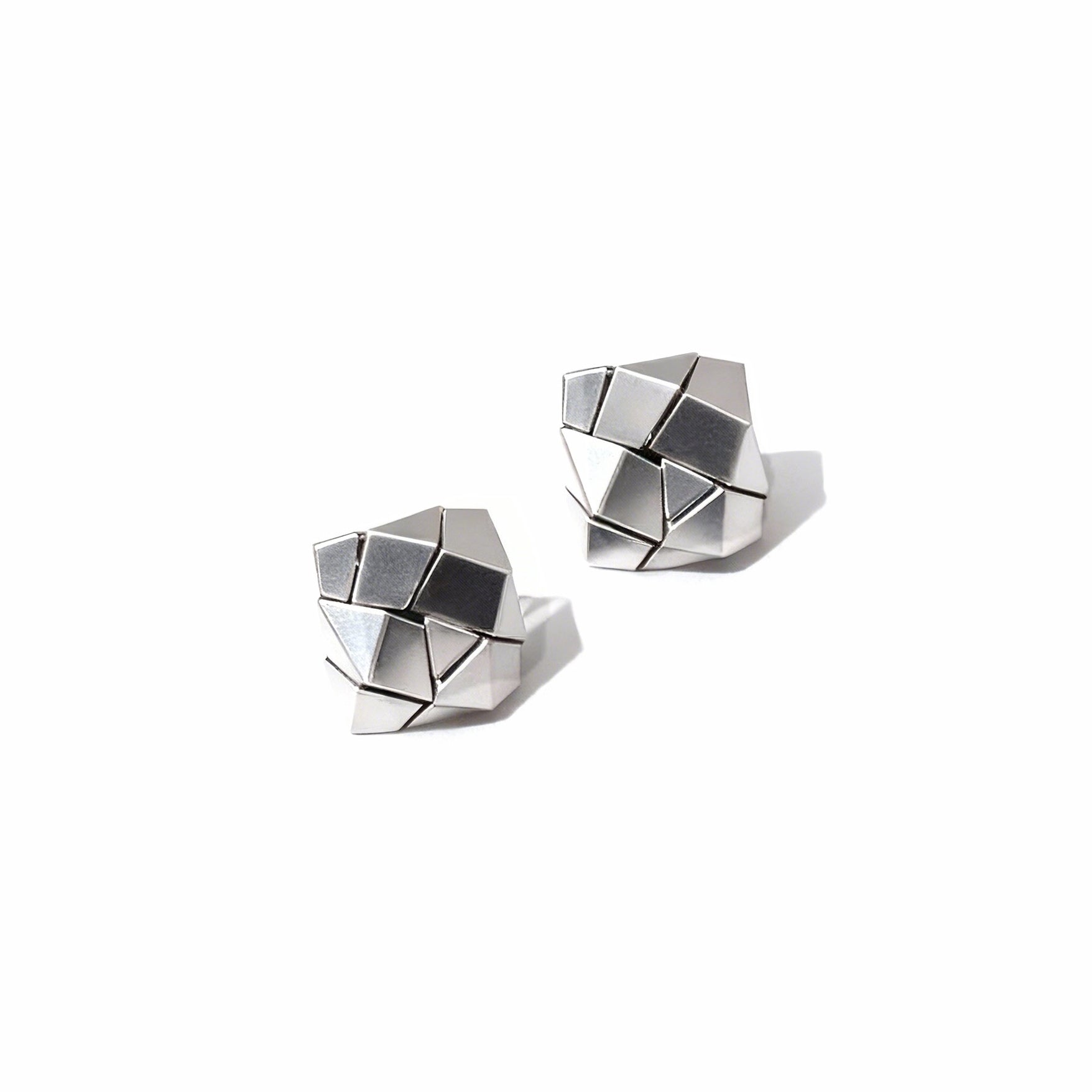 Pair of geometric silver earrings on a white background