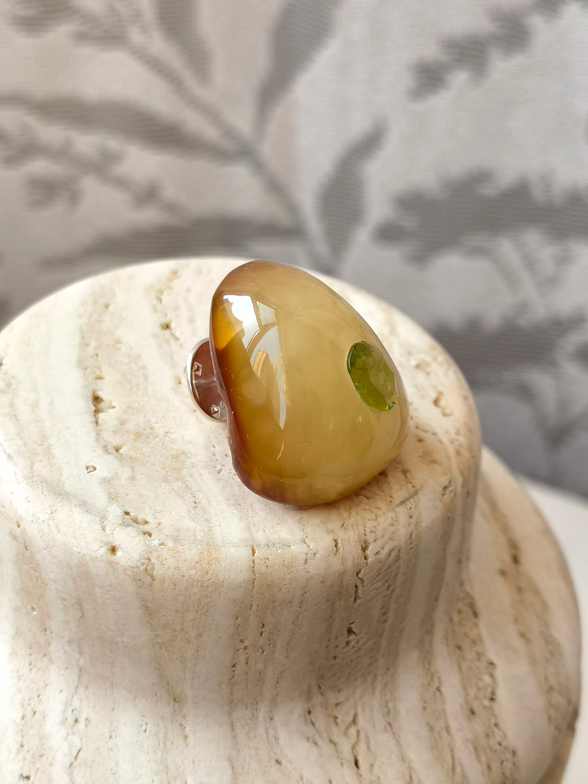 Handmade amber and peridot brooch symbolizing awareness, stillness, and a soft watching gaze.