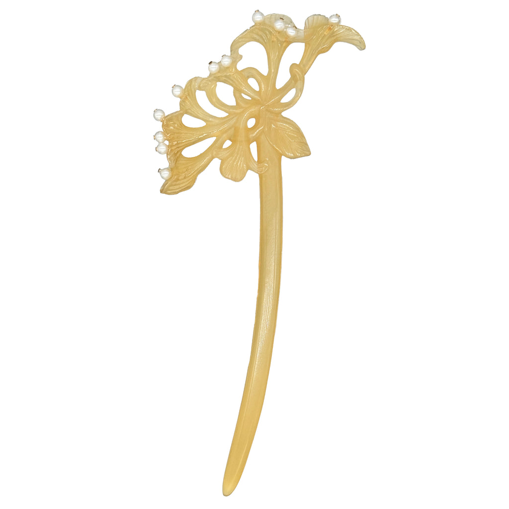 Decorative beige hairpin with floral design on a white background