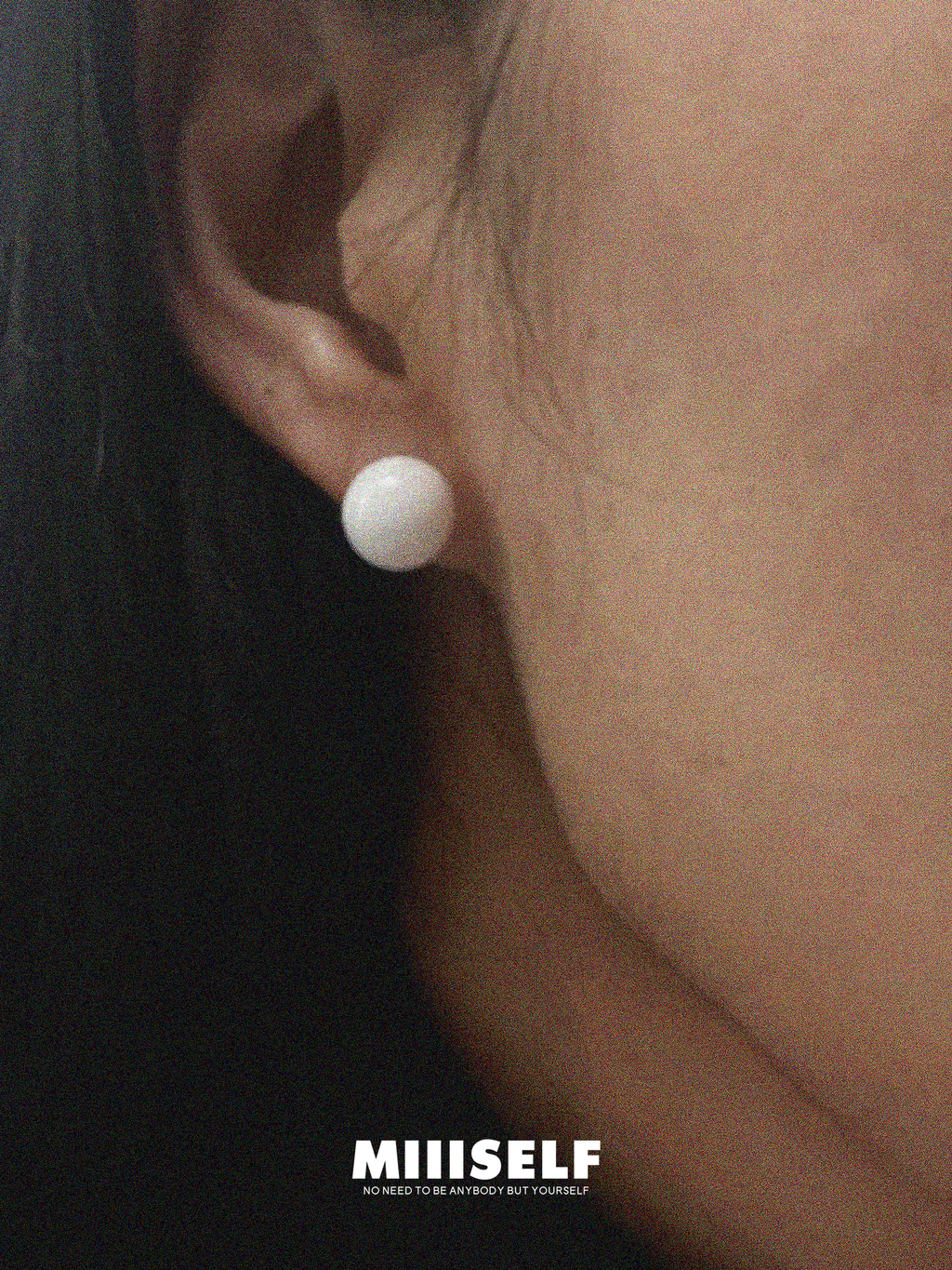 Ice Carved Silhouette White Agate Earrings — Close-up of an ear wearing a white pearl earring with 'MIISSELF' branding.