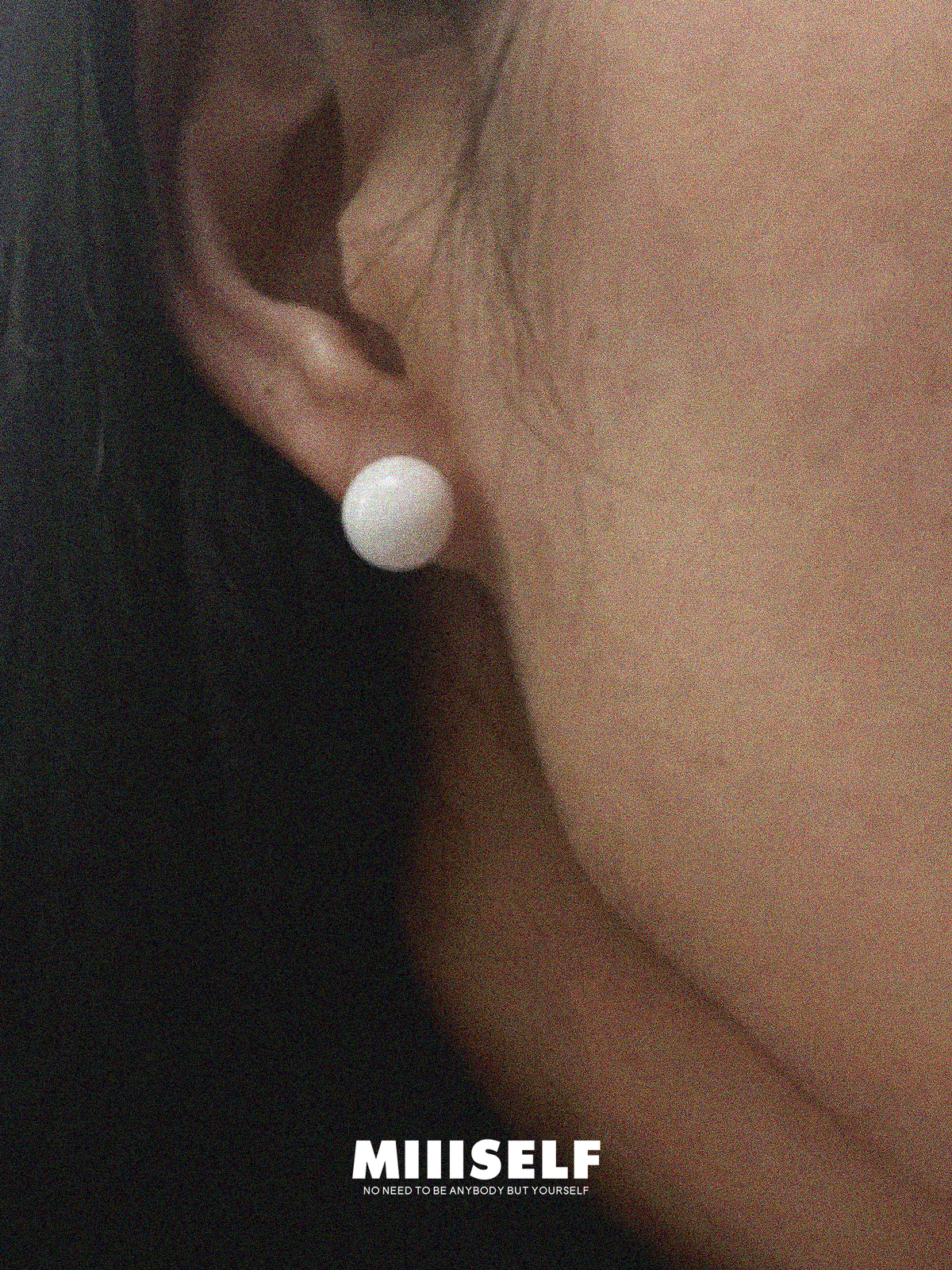Ice Carved Silhouette White Agate Earrings — Close-up of an ear wearing a white pearl earring with 'MIISSELF' branding.