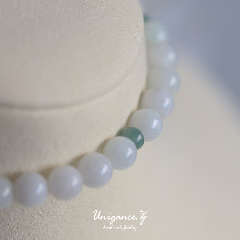 Icy Jade Bead Bracelet — Necklace with light blue beads on a white background, featuring the brand 'Unigance'.