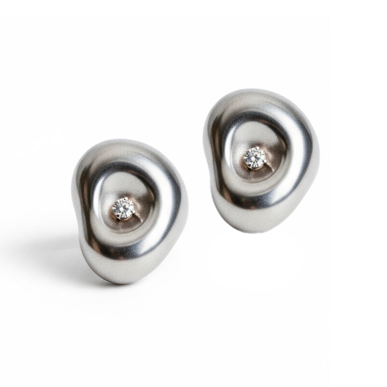 Pair of silver earrings with embedded diamonds on a white background