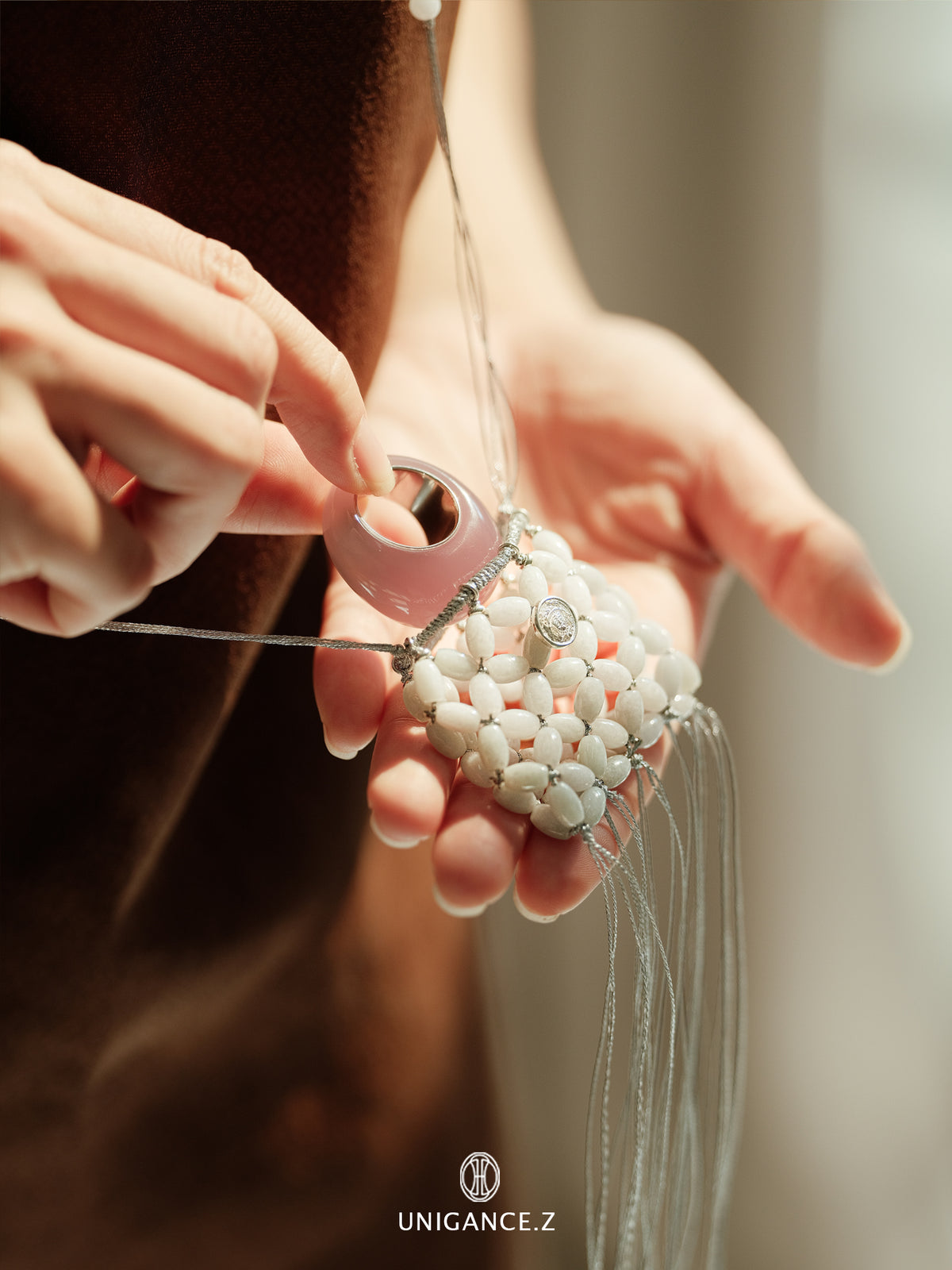 Jade Beaded Pouch — Close-up of hands working on a beaded earring with 'UNIGANCE' branding.