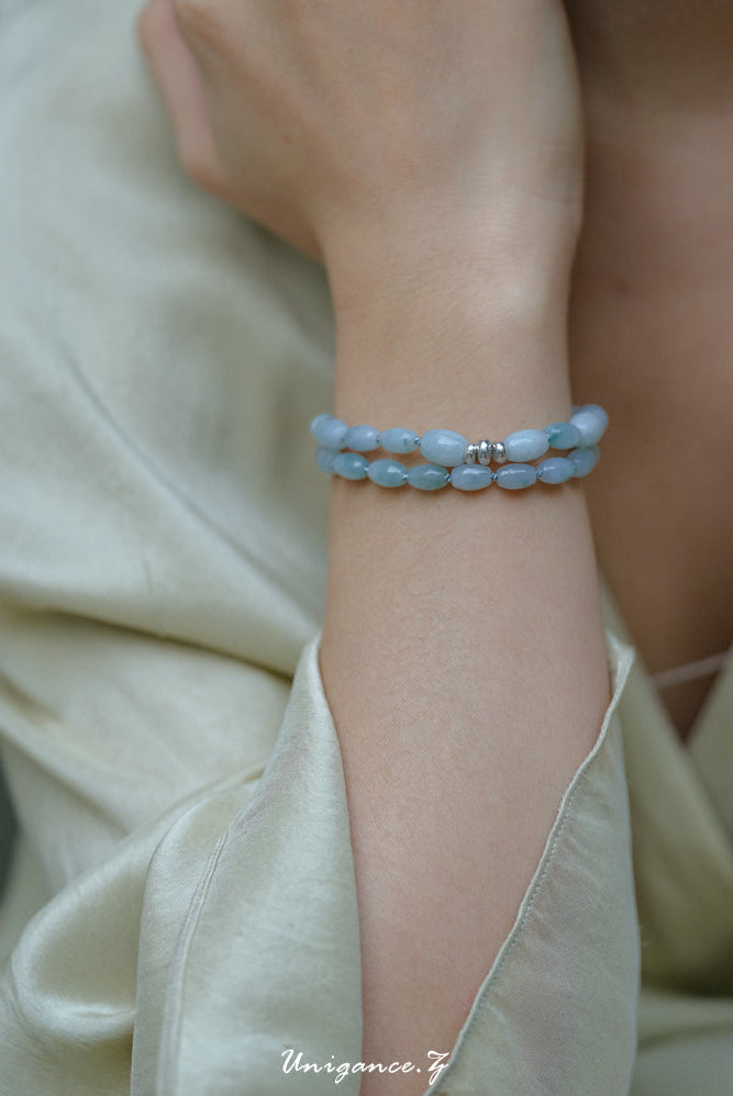 Light blue beaded bracelet on a wrist with a neutral background