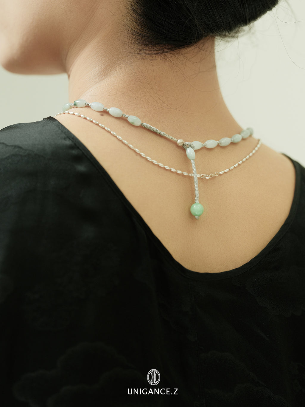 Jade Rice Bead Layered Necklace — Necklace with green pendant on a person wearing a black top, brand 'UNIGANCE' visible