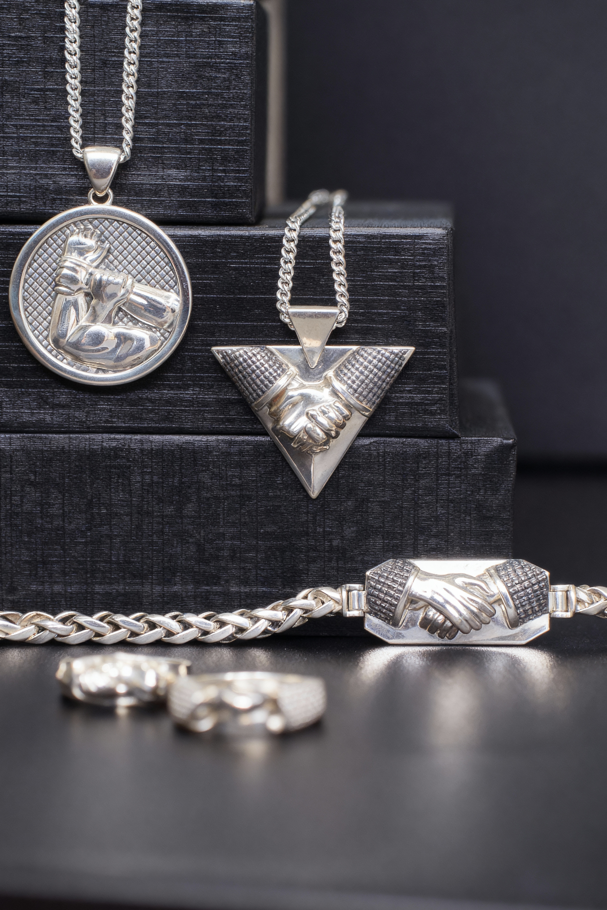 Collection of silver necklaces and pendants on a black background