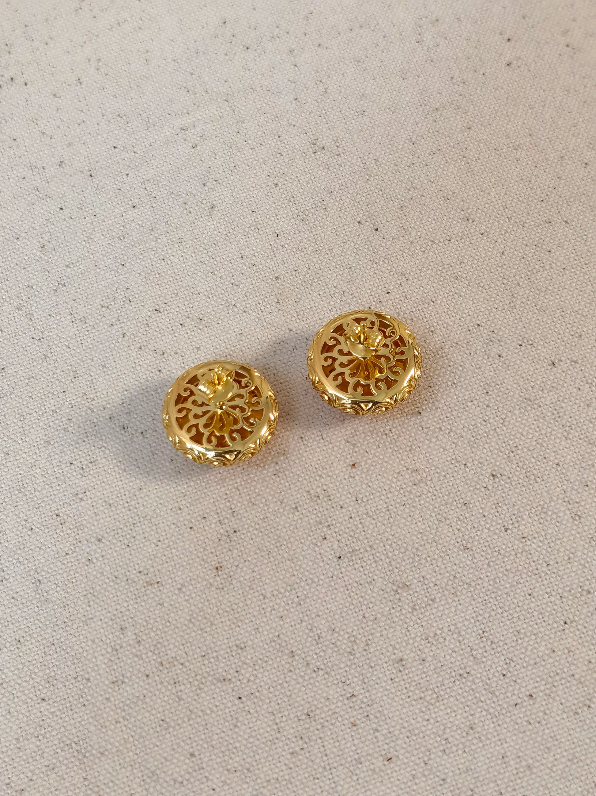 Pair of gold earrings on a light gray background
