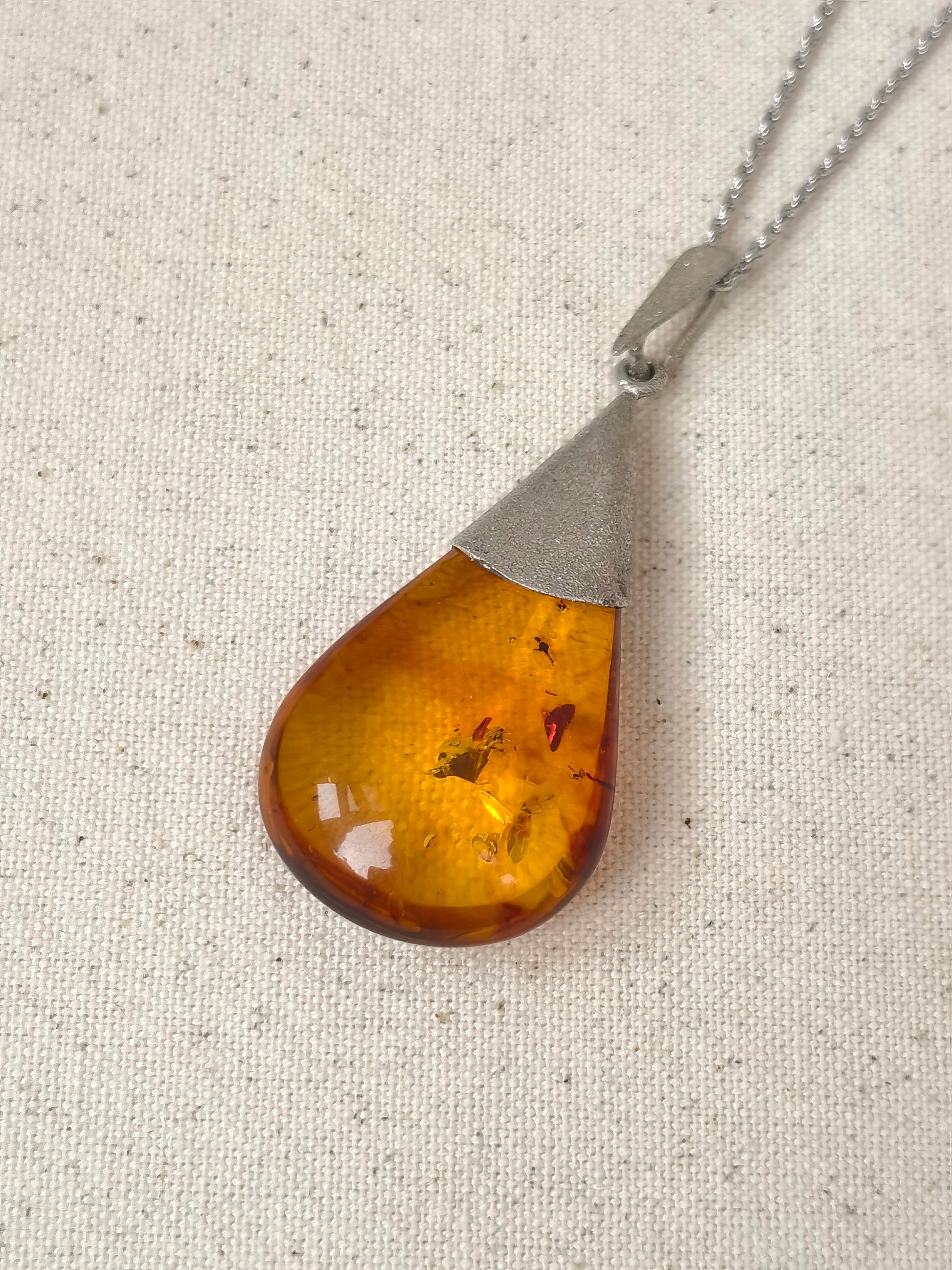 Meicily handmade amber necklace capturing organic inclusions and the serene glow of golden floral amber.