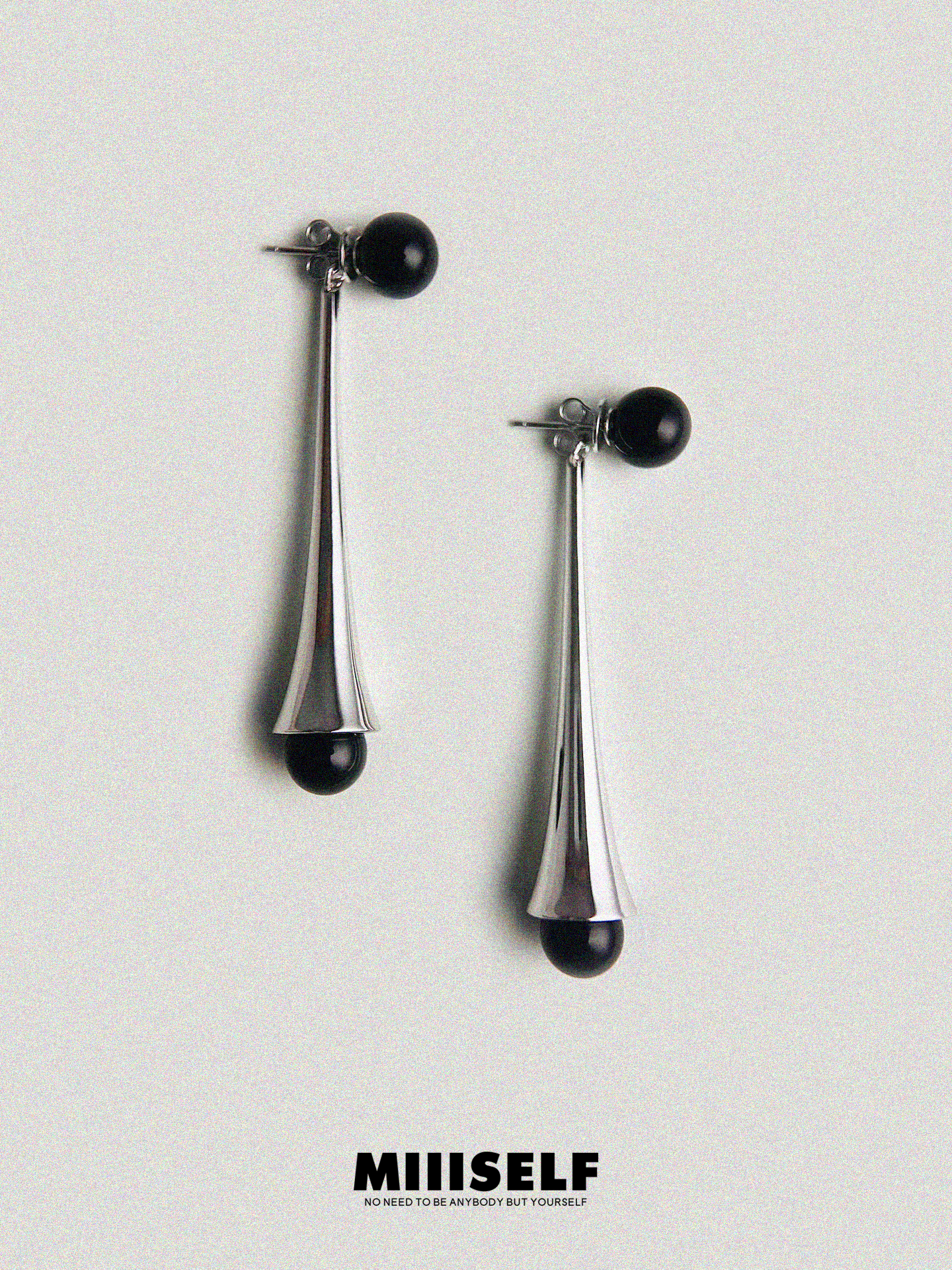 Pair of silver earrings with black beads on a light gray background, featuring the brand 'MIIISELF'.