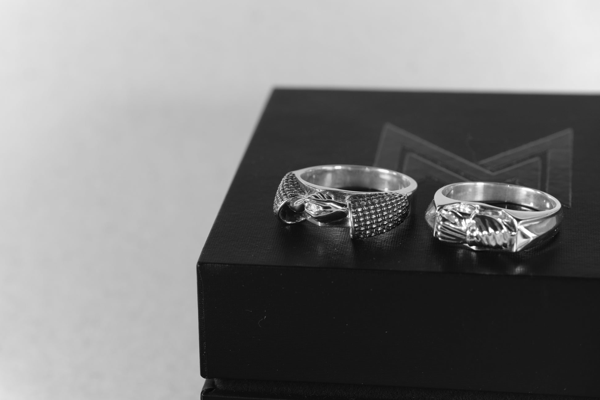 Two silver rings on a black box with a blurred background