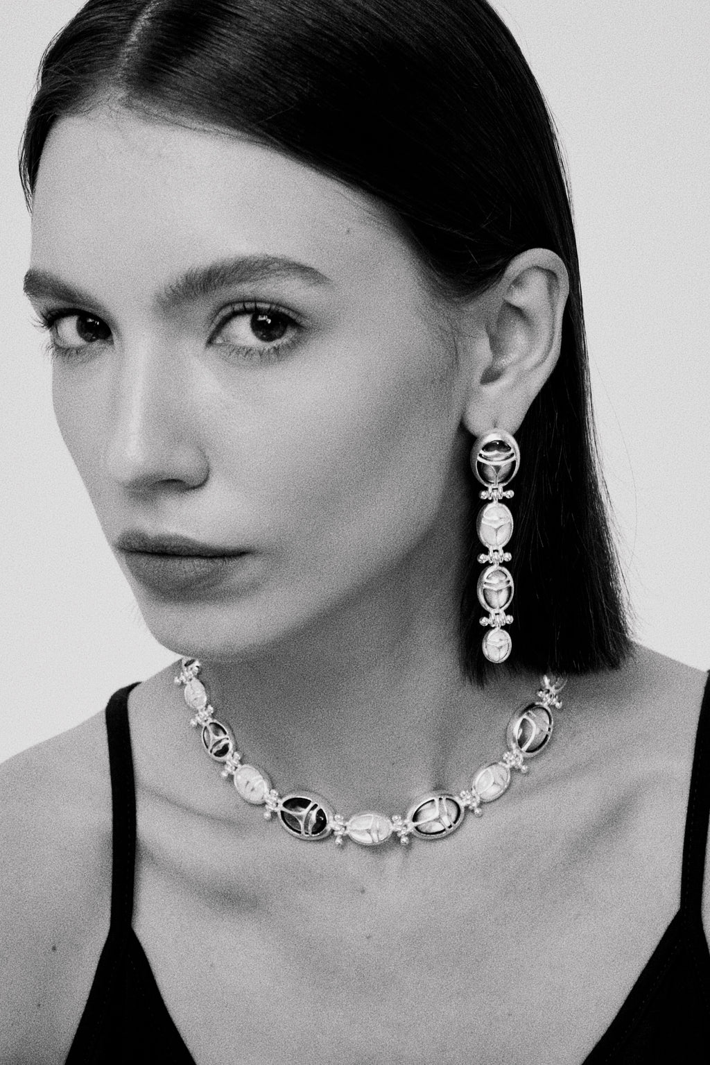 Nomadic Poem · Scarab Mother-of-Pearl Ouroboros Necklace — Black and white portrait of a woman wearing a necklace and
